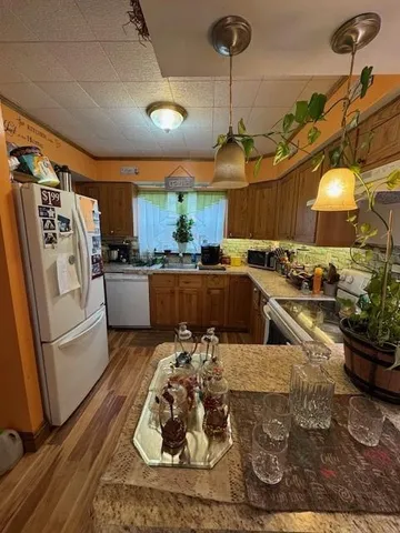 a kitchen with a sink and wooden floor