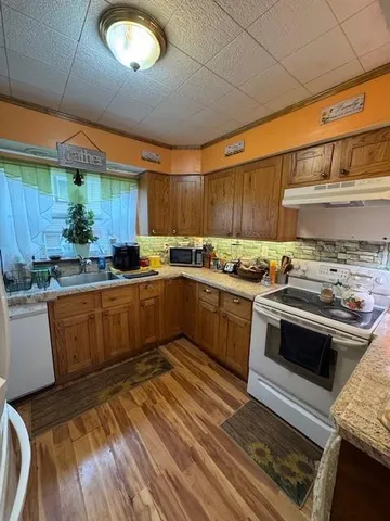 a kitchen with granite countertop a sink cabinets and stainless steel appliances