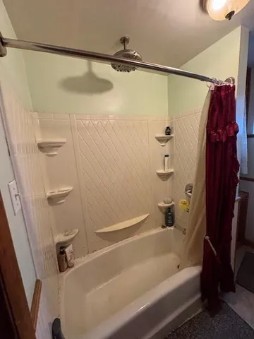 a bathroom with a shower and a bath tub