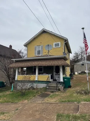 a view of a house with large windows and a small yard
