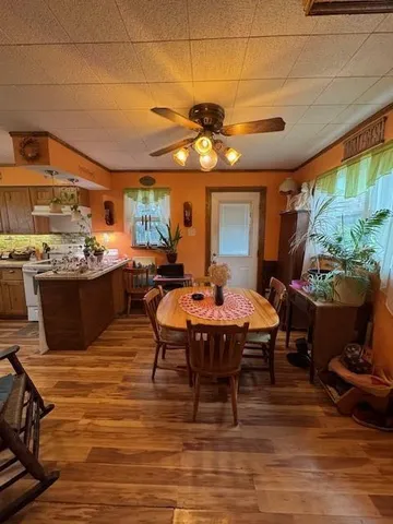 a view of a dining room with furniture a chandelier and wooden floor