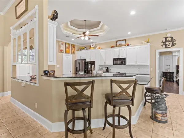 a kitchen with stainless steel appliances kitchen island granite countertop a table and chairs in it
