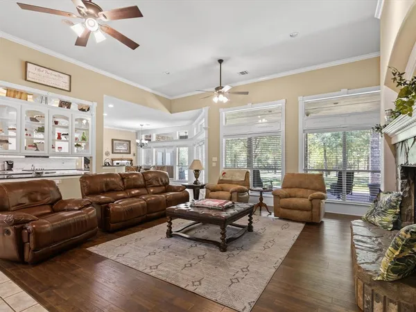 a living room with furniture ceiling fan and a large window