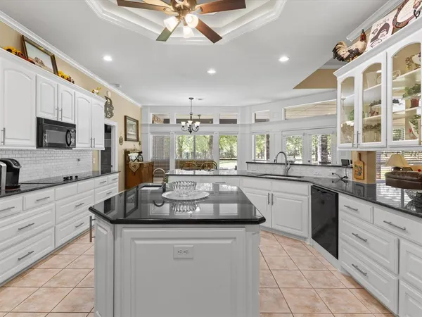 a kitchen with kitchen island granite countertop a stove and a sink
