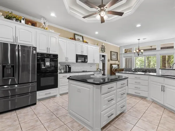 a kitchen with stainless steel appliances kitchen island granite countertop a refrigerator and a sink
