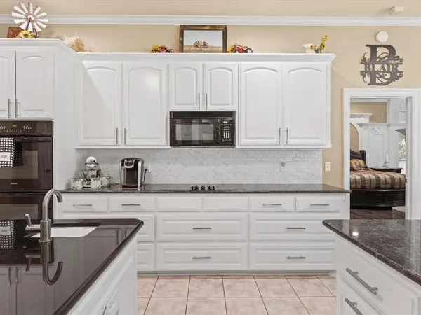 a kitchen with granite countertop a sink a stove and cabinets