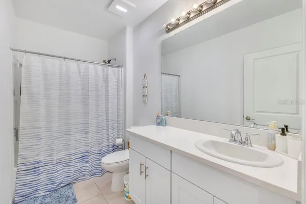 a bathroom with a double vanity sink toilet and a mirror