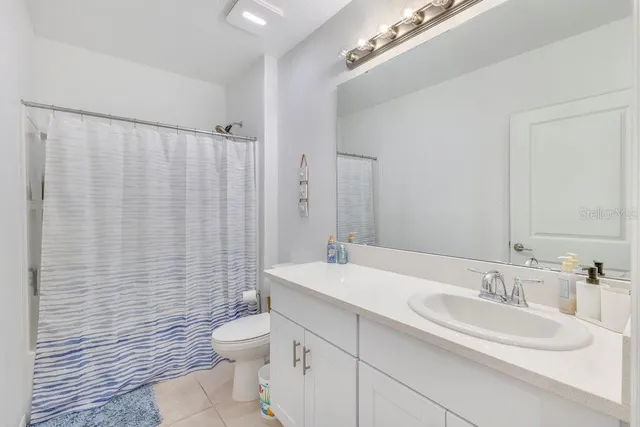a bathroom with a double vanity sink toilet and a mirror