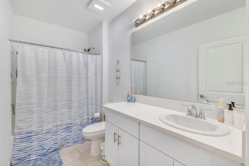 4255 Southern Vista Loop St. Cloud, FL 34772 - Photo 17 of 34 a bathroom with a double vanity sink toilet and a mirror