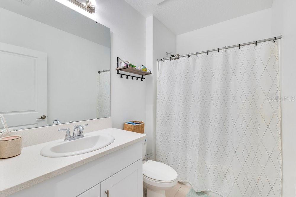 4255 Southern Vista Loop St. Cloud, FL 34772 - Photo 20 of 34 a bathroom with a sink a toilet and shower curtain