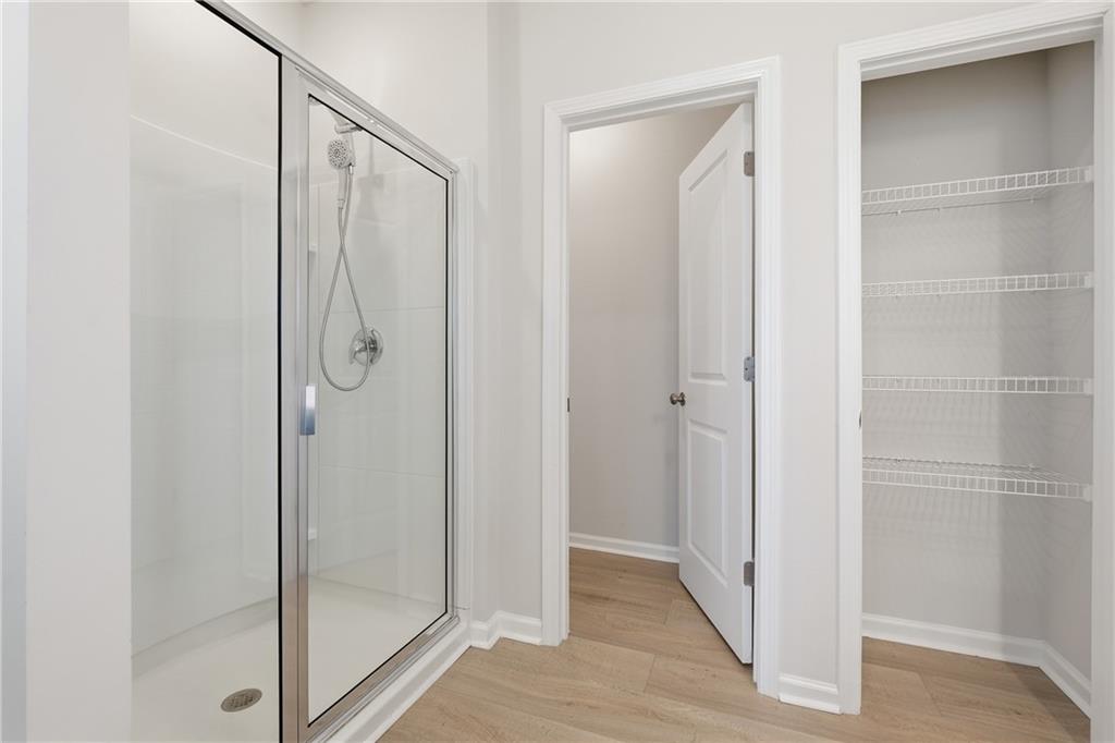 8820 Shipton Circle Ball Ground, GA 30107 - Photo 17 of 40 a bathroom with a glass shower door