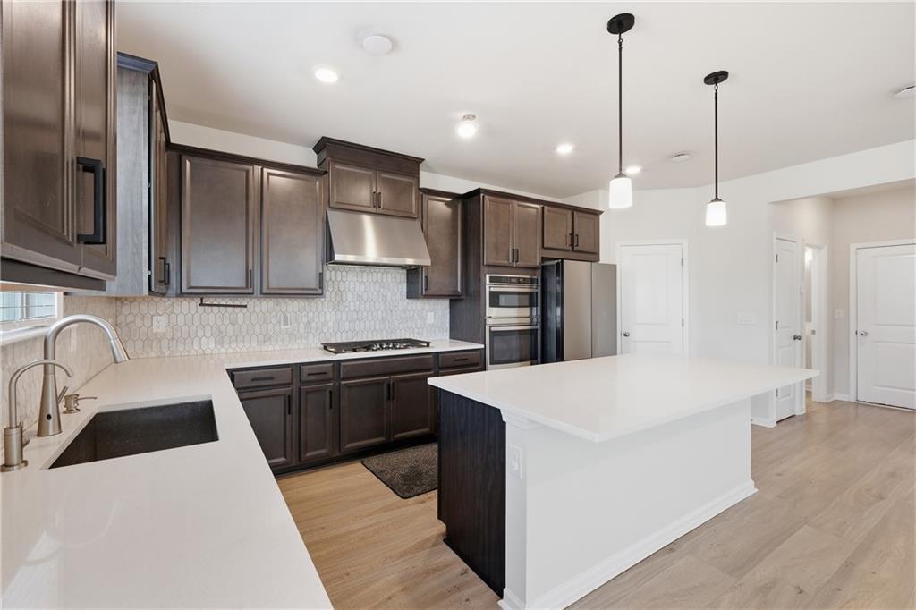 8820 Shipton Circle Ball Ground, GA 30107 - Photo 9 of 40 a kitchen with stainless steel appliances kitchen island a sink a stove a refrigerator and cabinets