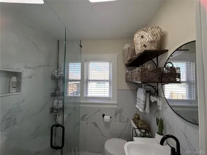a bathroom with a toilet a sink and mirror
