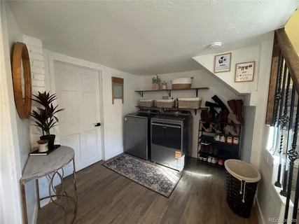 a living room with stainless steel appliances furniture a rug and a window