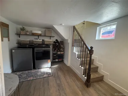 a view of a kitchen with furniture and wooden floor