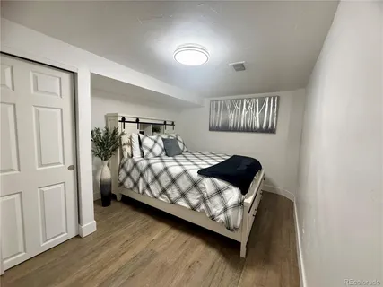 a bedroom with a bed window and a night stand