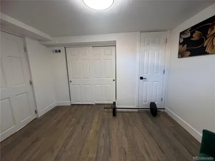 a view of a room with wooden floor and a window