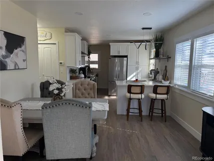 a dining room with furniture and wooden floor