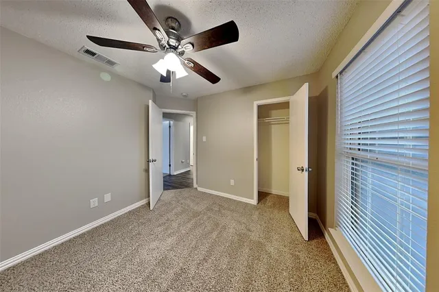 a view of an empty room with a ceiling fan