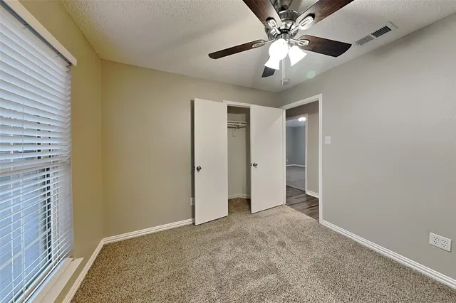 a view of an empty room and a ceiling fan