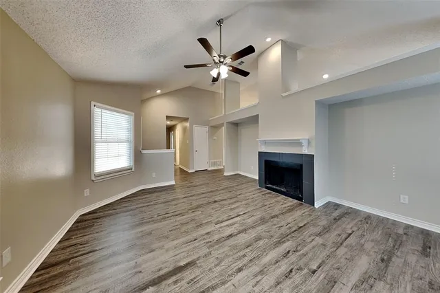 a view of an empty room with window and fireplace