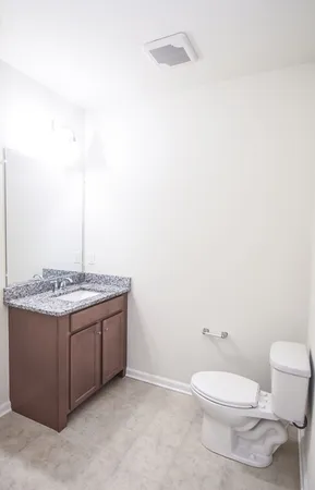 a bathroom with a granite countertop toilet and a sink