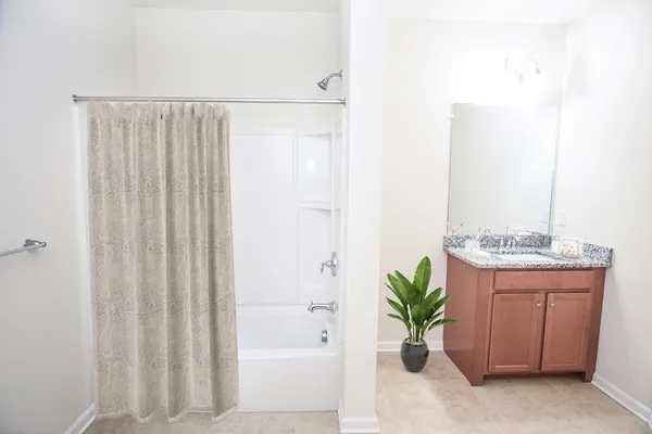 a bathroom with a granite countertop sink a toilet and a bathtub