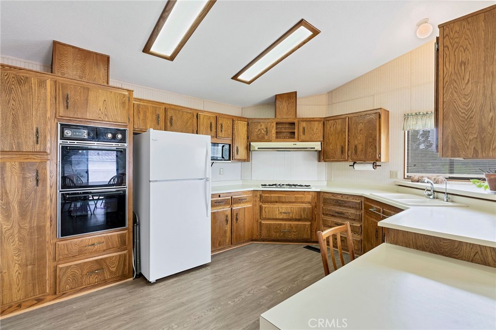 24800 Cornstalk Road Wildomar, CA 92595 - Photo 4 of 23 a kitchen with stainless steel appliances sink refrigerator and microwave