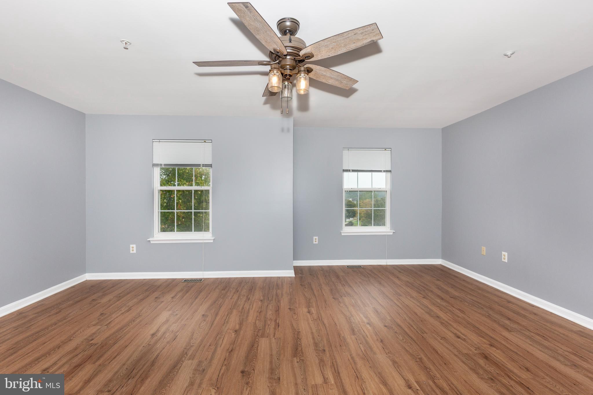 313-3 Sirens Court Odenton, MD 21113 - Photo 18 of 30 a view of an empty room with wooden floor and a window