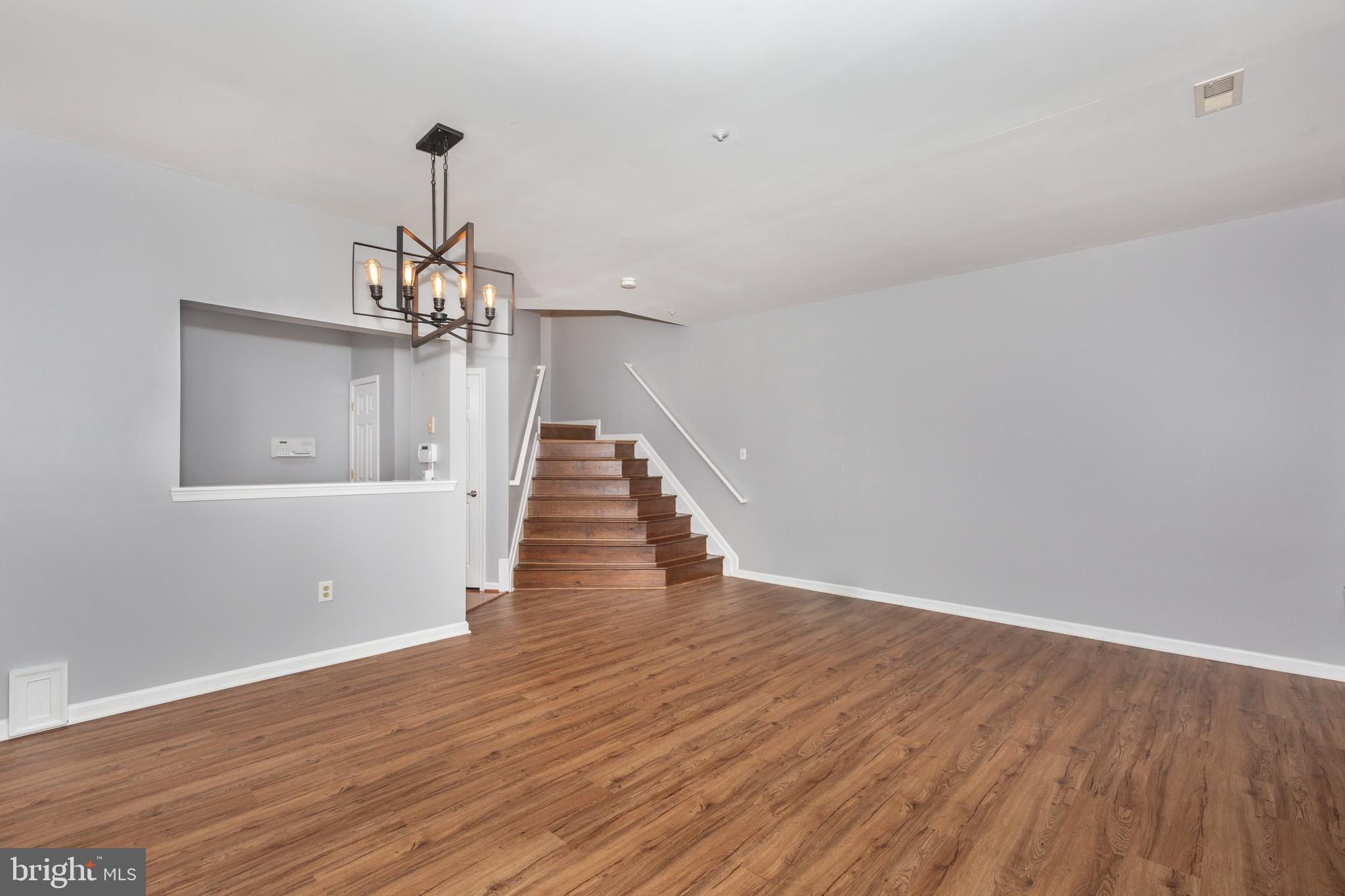 313-3 Sirens Court Odenton, MD 21113 - Photo 2 of 30 a view of a room with wooden floor staircase and a chandelier