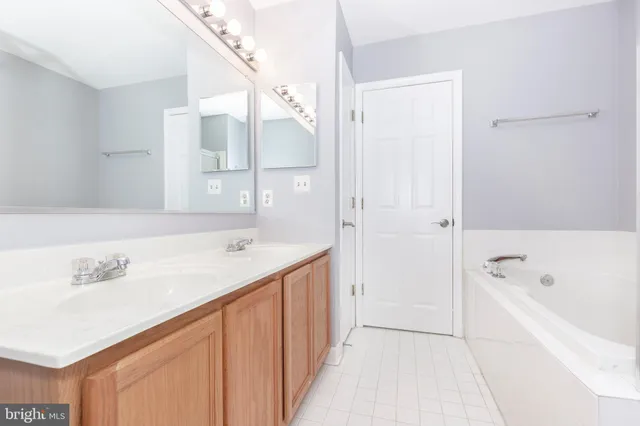 a bathroom with a tub a sink and mirror