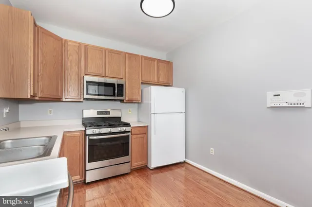 a kitchen with granite countertop a sink cabinets and stainless steel appliances