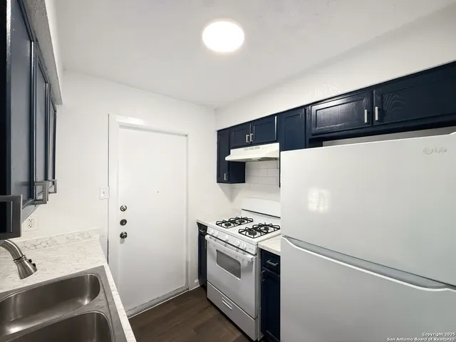 a kitchen with a sink and a stove top oven