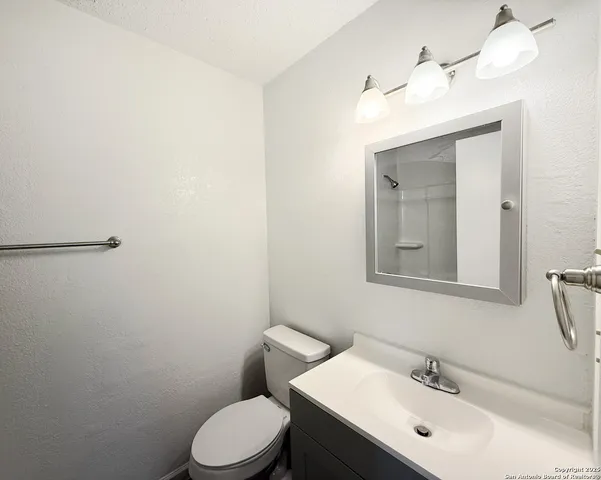a bathroom with a toilet a sink and mirror