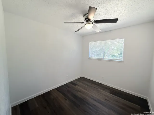 a view of a room with wooden floor and fan