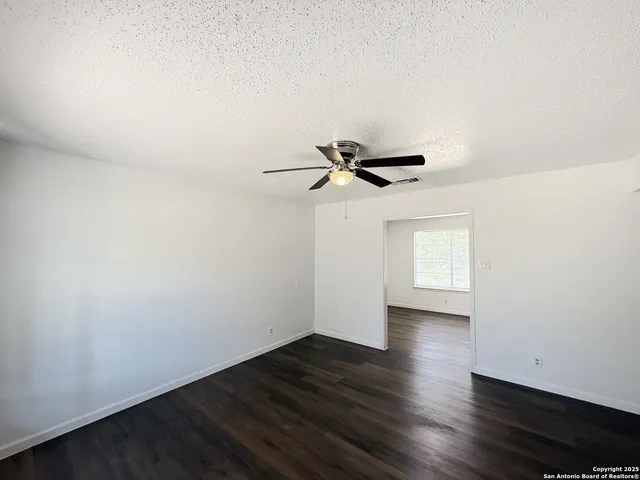 a view of a room with wooden floor and white walls