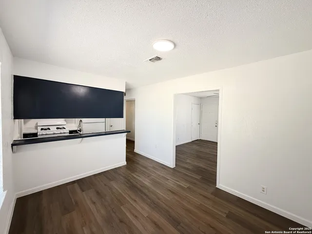 a living room with wooden floor and flat screen tv