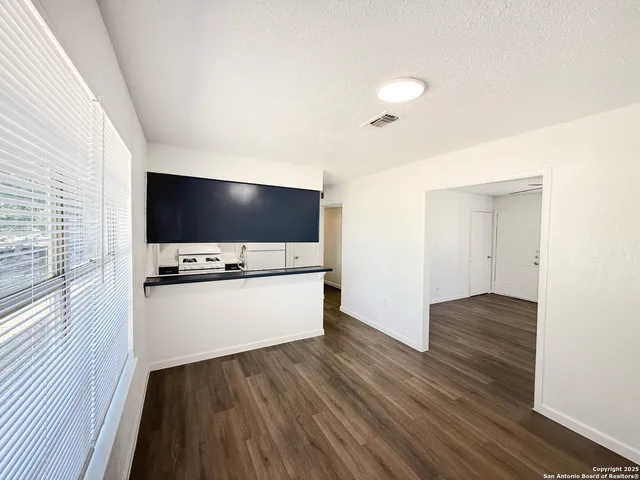 a view of room with wooden floor and flat screen tv
