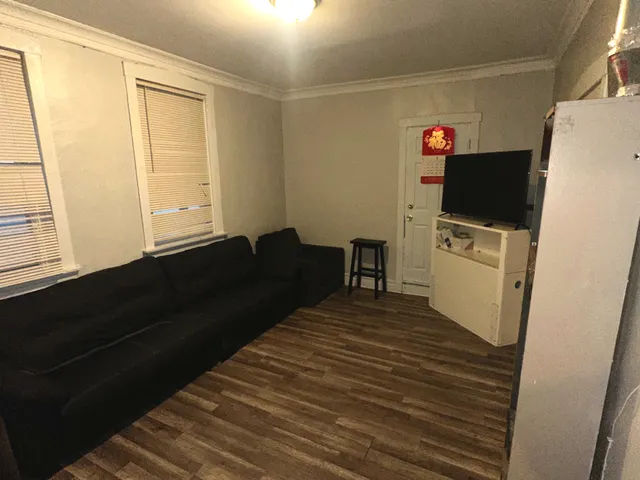 a living room with a bed furniture and a flat screen tv