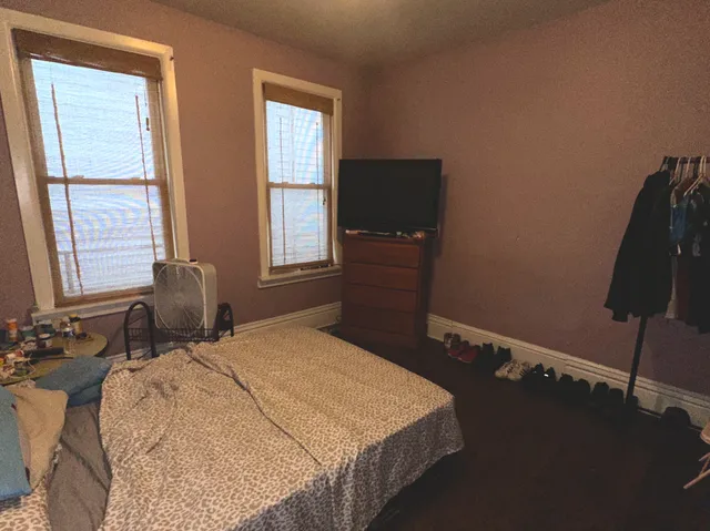 a bedroom with a bed and two windows