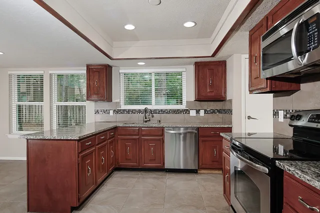 a kitchen with stainless steel appliances granite countertop a sink stove and cabinets