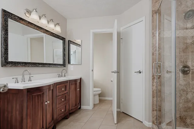 a bathroom with a double vanity sink a toilet and a mirror