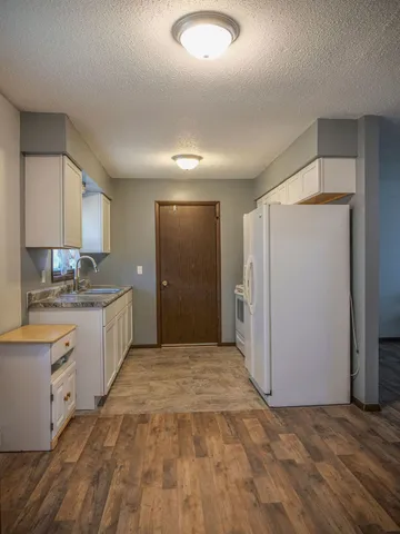 a kitchen with granite countertop a sink and a refrigerator