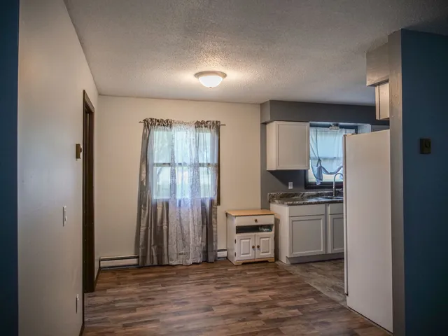 a kitchen with granite countertop a refrigerator stove and sink
