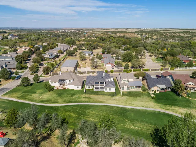an aerial view of residential houses with outdoor space and ocean view