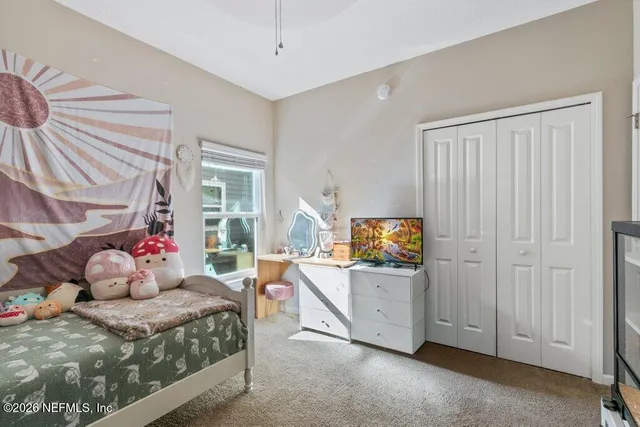 a bed sitting in a bedroom next to a book shelf