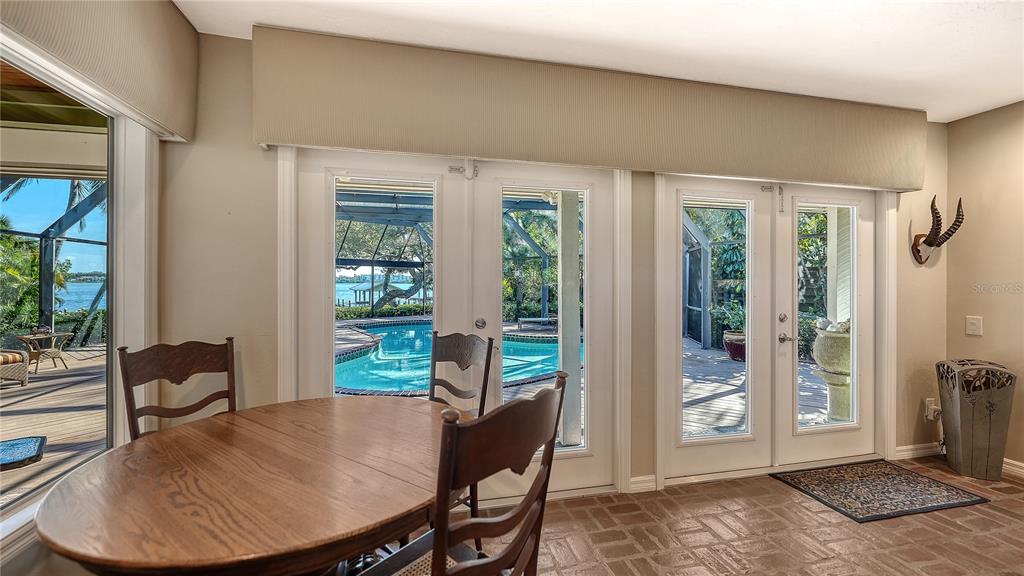1042 North Casey Key Road Nokomis, FL 34275 - Photo 13 of 77 a view of a dining room with furniture wooden floor and a potted plant