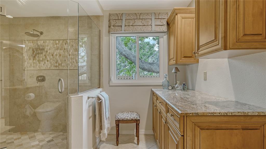 1042 North Casey Key Road Nokomis, FL 34275 - Photo 30 of 77 a bathroom with a granite countertop shower a mirror and a sink