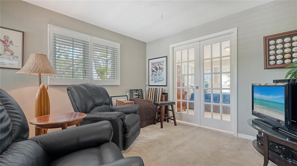 1042 North Casey Key Road Nokomis, FL 34275 - Photo 43 of 77 a living room with furniture a flat screen tv and a window