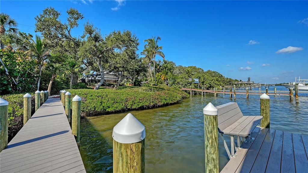 1042 North Casey Key Road Nokomis, FL 34275 - Photo 55 of 77 a view of a wooden chairs and table on wooden deck with swimming pool